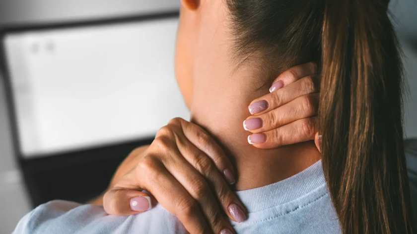 Woman touching the pain points in her neck.