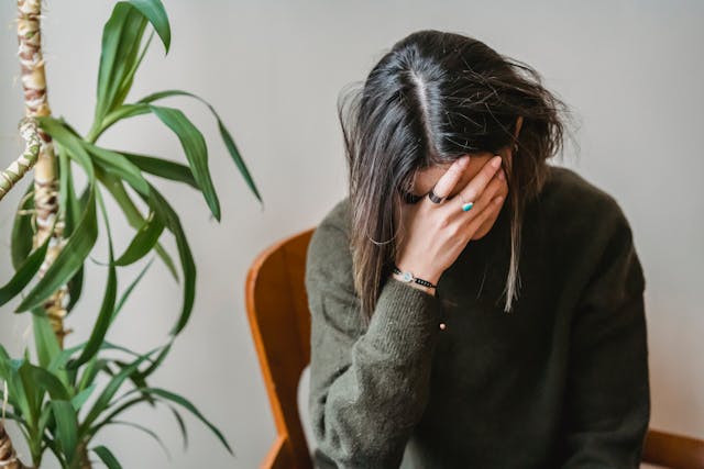 A stressed woman putting her hand on her head